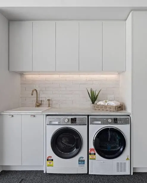 White laundry with subway tile splashback, LED strip lighting and side by side washer and dryer